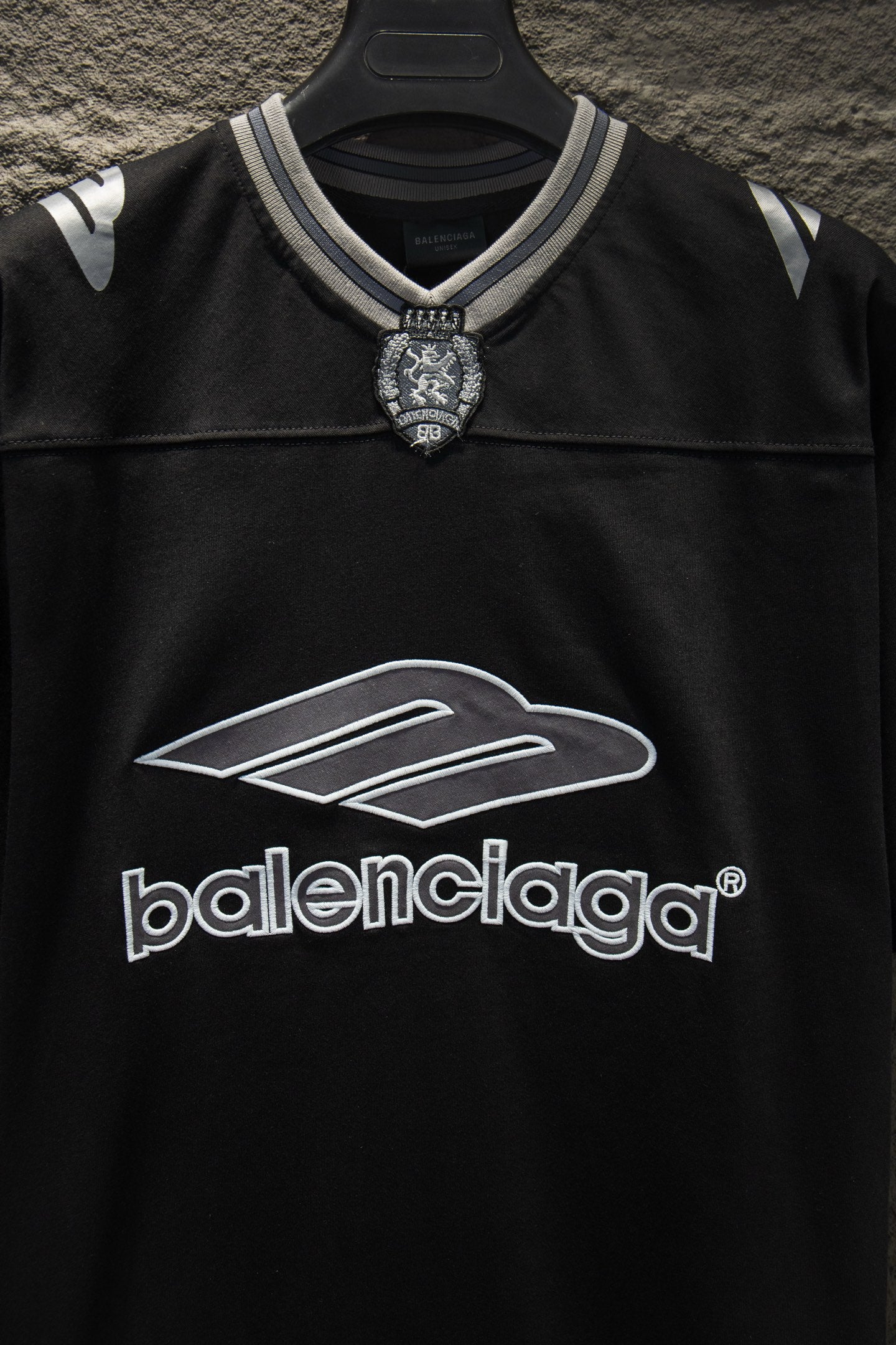 Balenciaga black polo shirt close-up of logo graphic and striped neckline