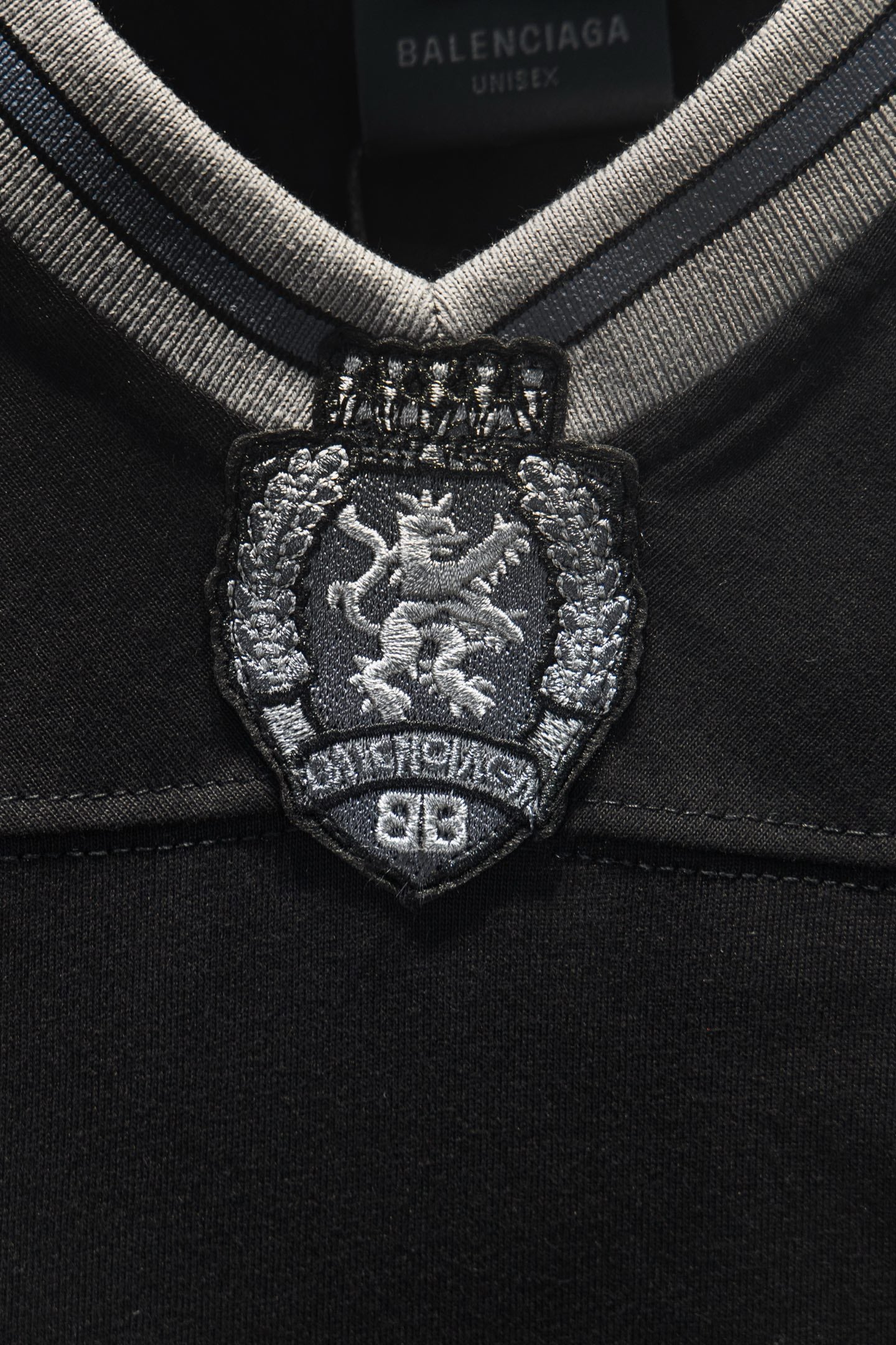 Balenciaga embroidered coat-of-arms crest at V-neck placket