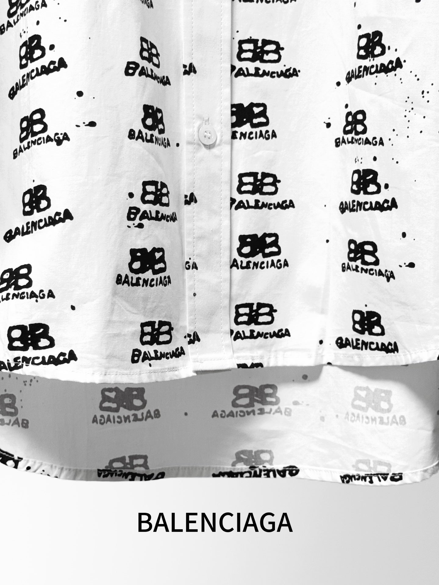 White shirt hem and lower button area with black logo pattern, straight hem.