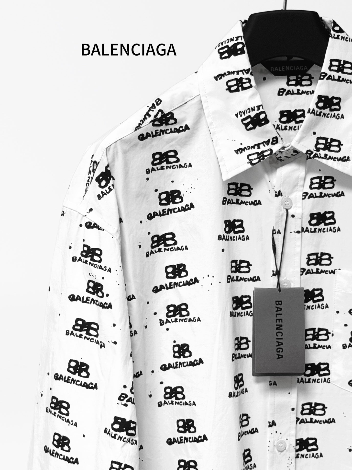 White long-sleeve shirt with black logo icon and text pattern, button-front.
