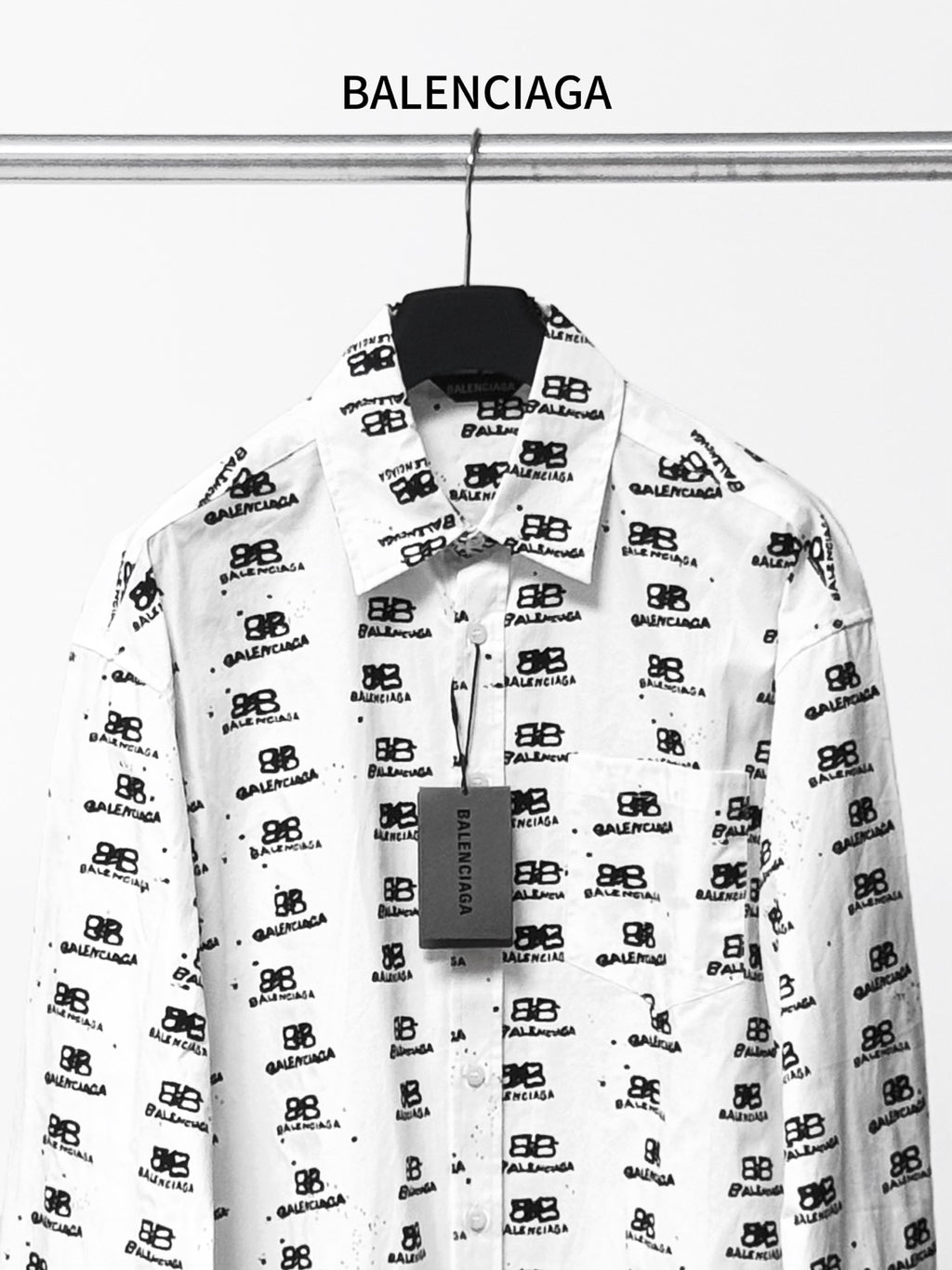 White long-sleeve shirt with black logo pattern, front view.