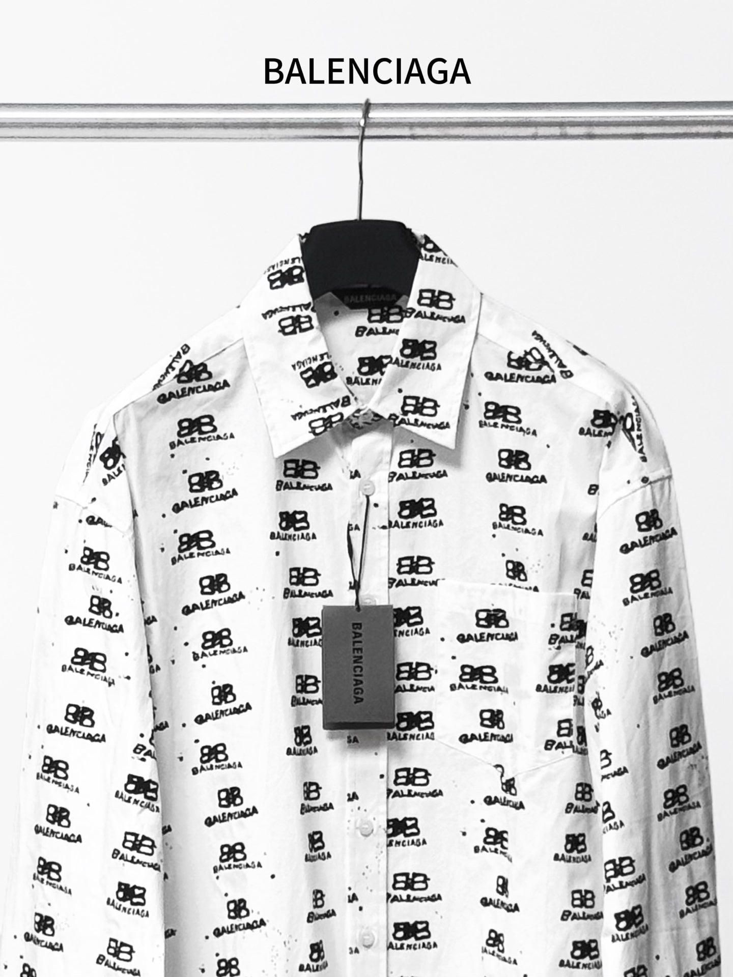 White long-sleeve shirt with black logo pattern, front view.