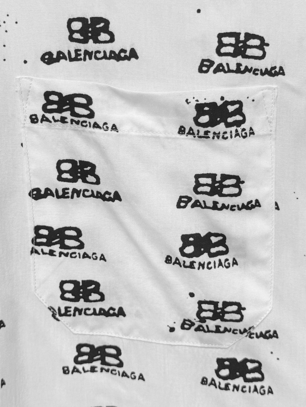 Balenciaga shirt fabric close-up: white cotton with black Balenciaga logo symbols