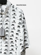 Balenciaga long-sleeve shirt close-up: white fabric with black repeating logo marks