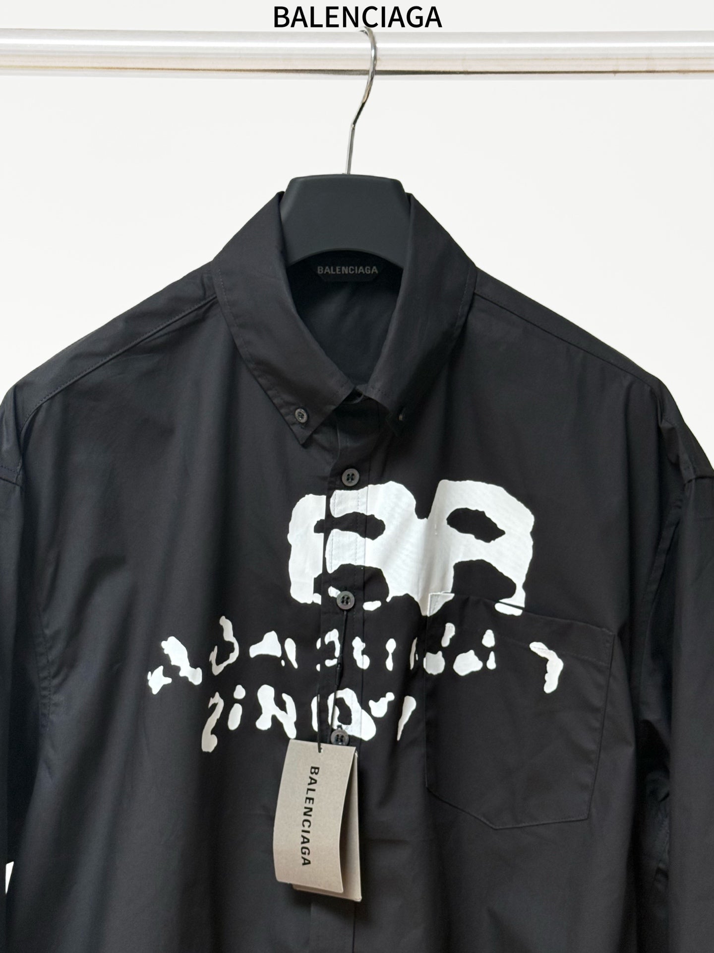 Balenciaga black long-sleeve button-up shirt detail view of front graphic and chest pocket