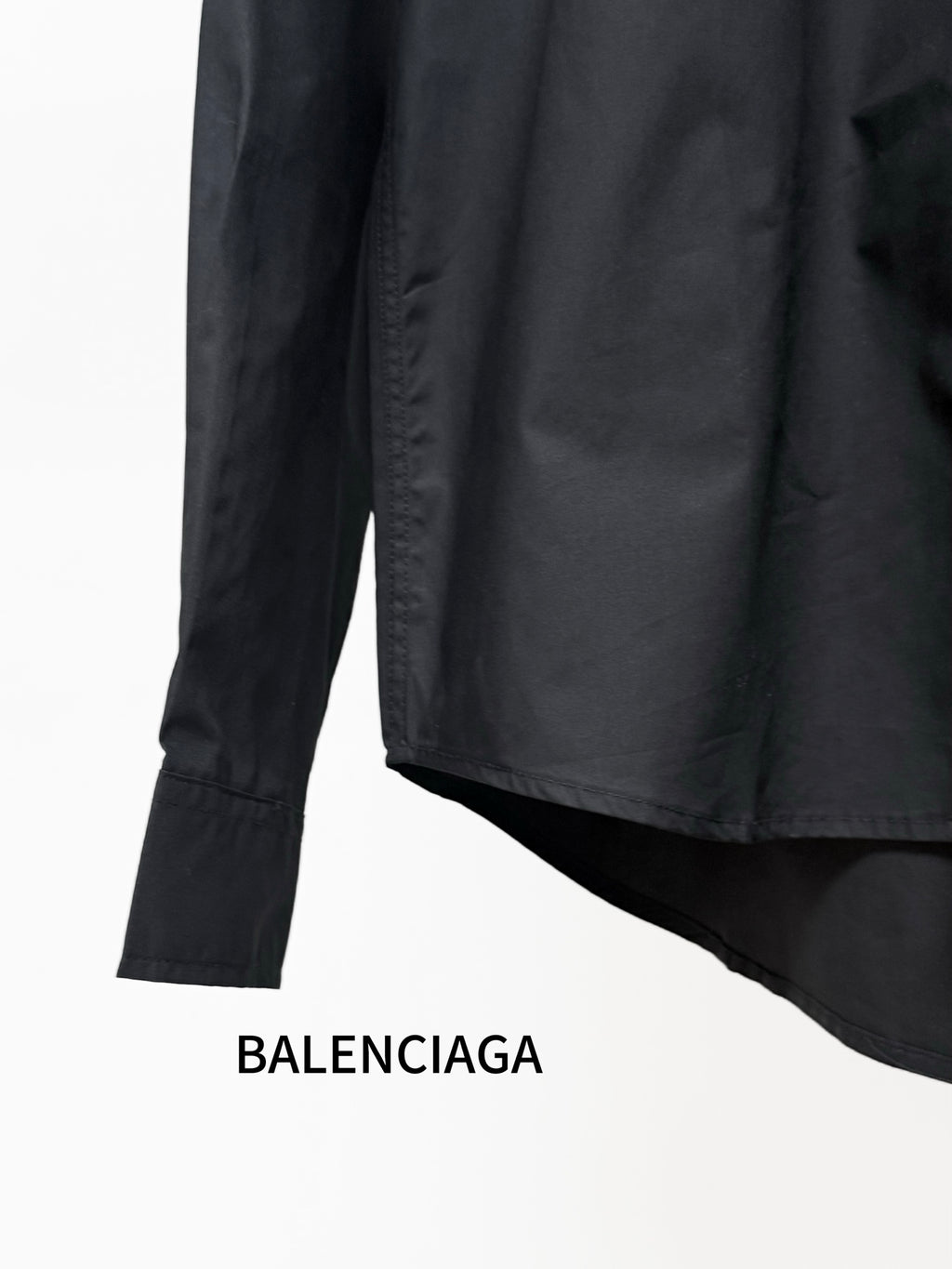Black long-sleeve shirt with curved hem and button cuffs