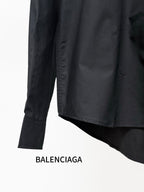 Black long-sleeve shirt with curved hem and button cuffs