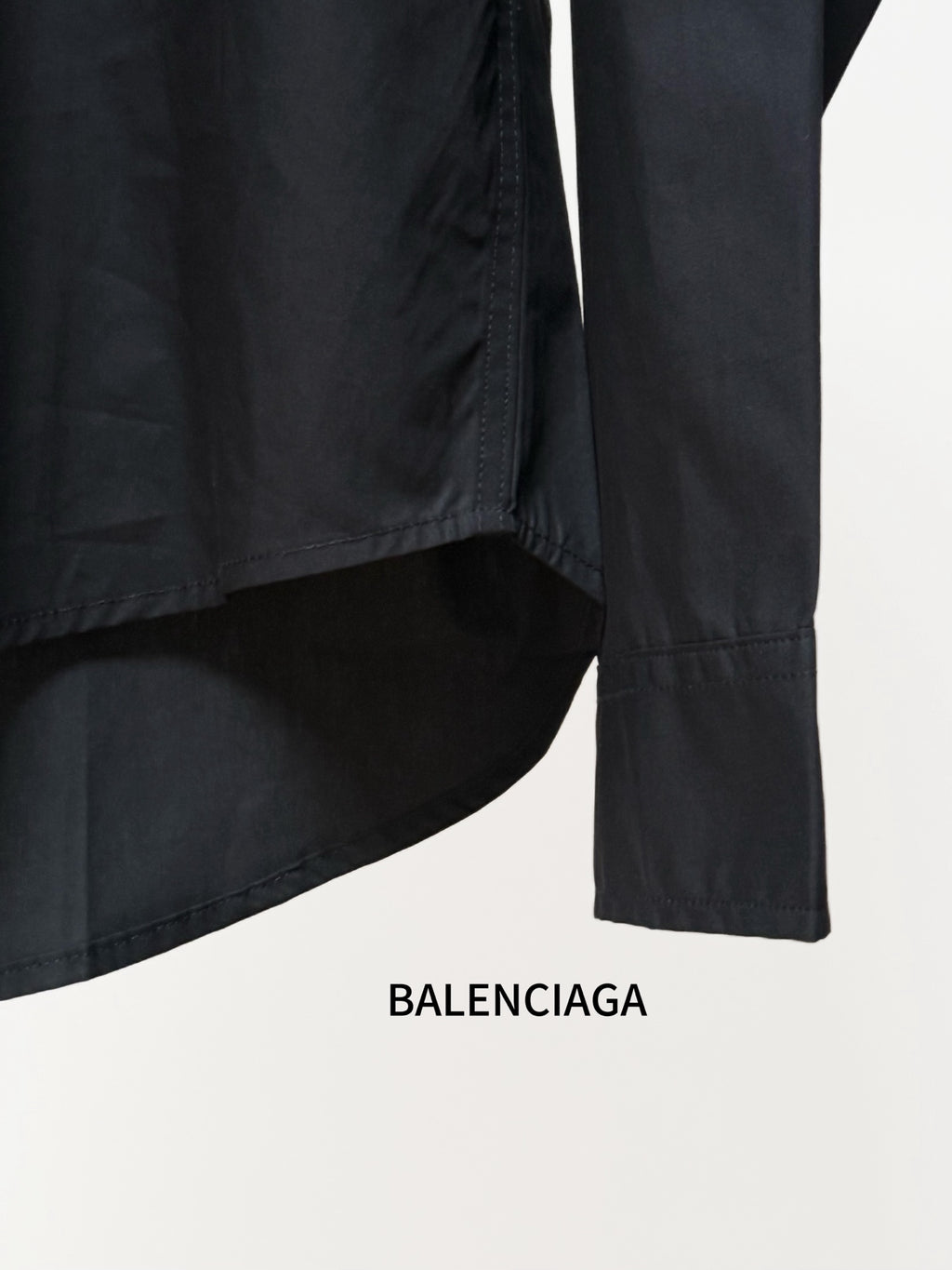 Balenciaga black long-sleeve button-up shirt sleeve and hem close-up with side seam