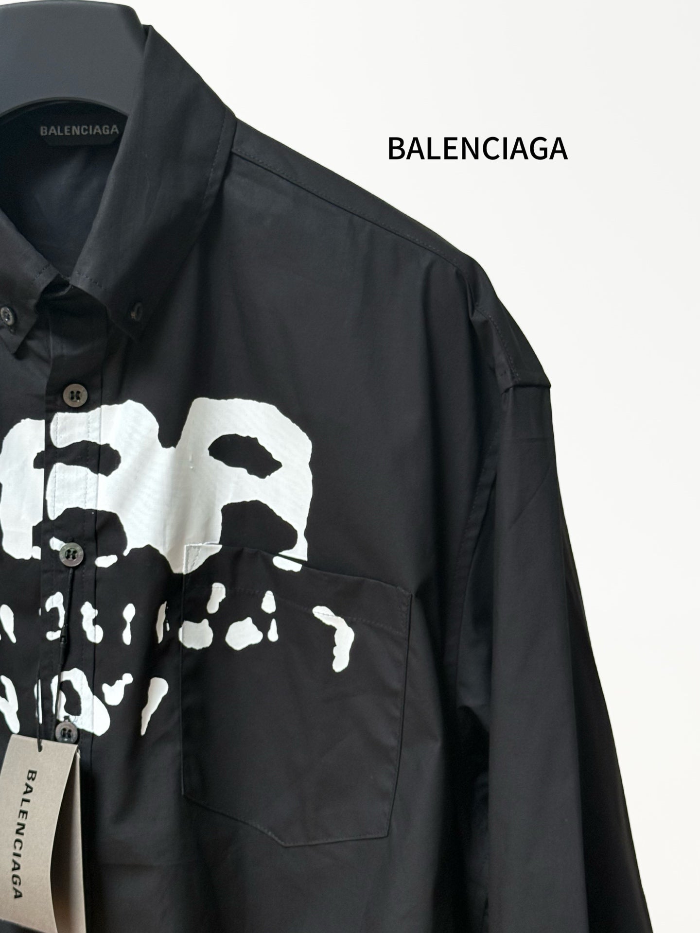 Black long-sleeve shirt with chest pocket and skull graphic print