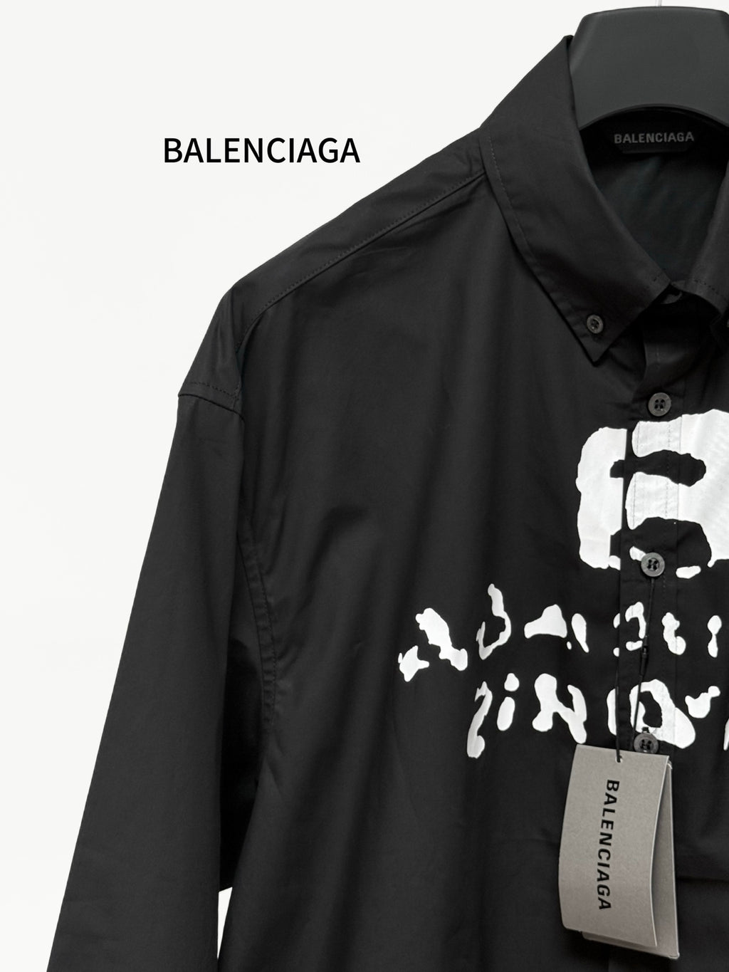 Black long-sleeve button shirt with close-up skull graphic and brand tag