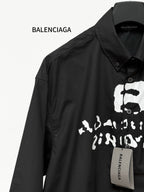 Black long-sleeve button shirt with close-up skull graphic and brand tag