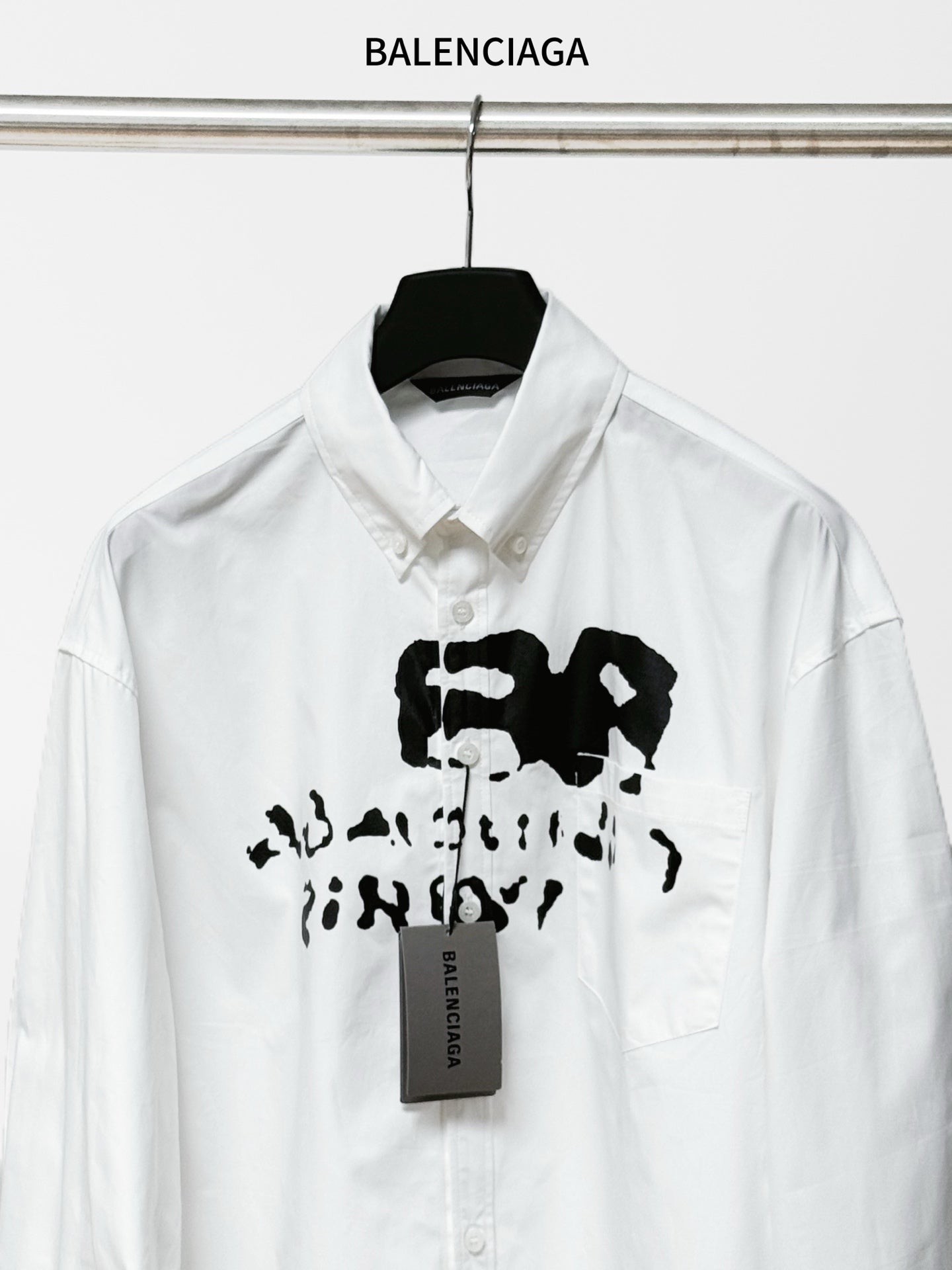 White Balenciaga button-up shirt close-up of front black graphic and tag