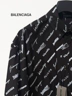 Black long-sleeve button-up shirt with repeating white script logo pattern, shoulder close-up