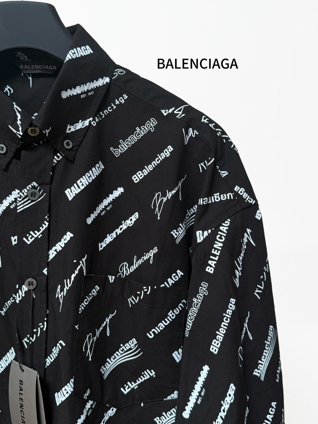 Black long-sleeve button-up shirt with repeating white script logo pattern, chest and placket
