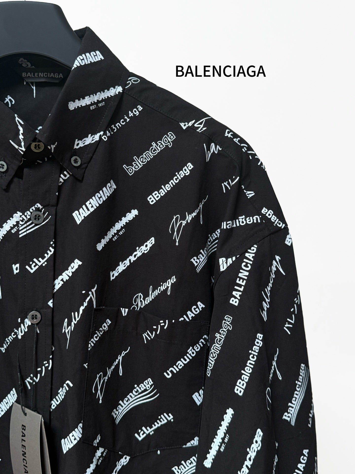 Black long-sleeve button-up shirt with repeating white script logo pattern, chest and placket