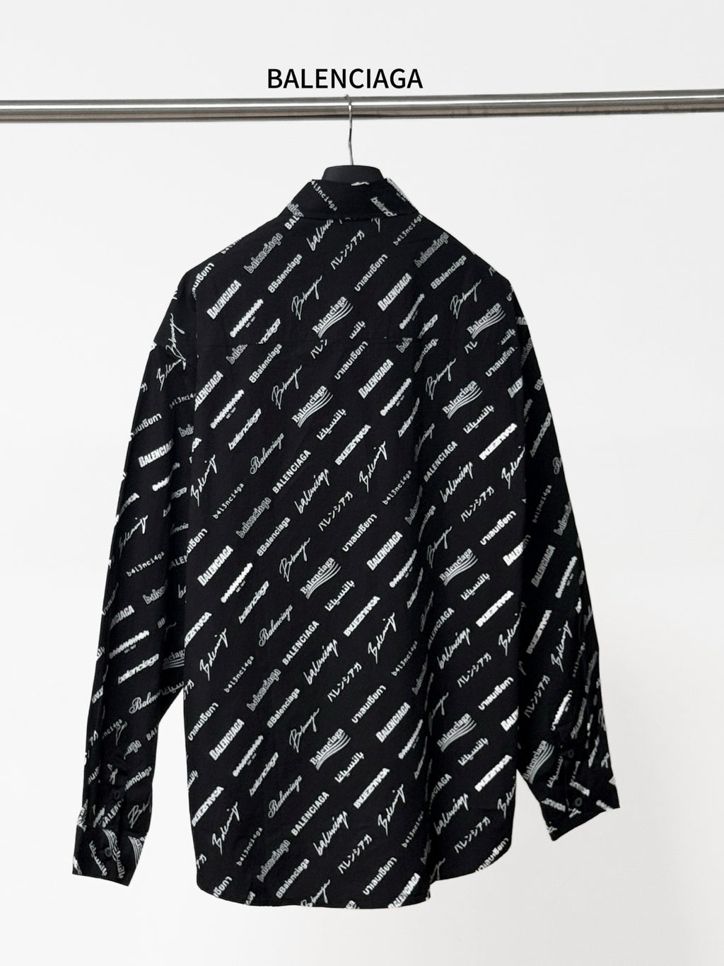 Black long-sleeve button-up shirt with repeating white script logo pattern, back view