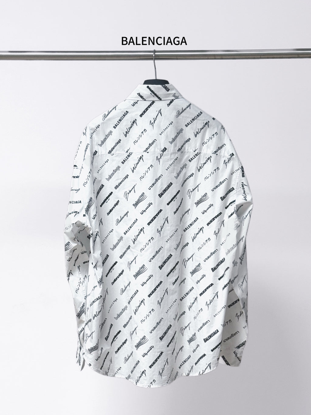 White long-sleeve shirt with spread collar, black Balenciaga script print on back