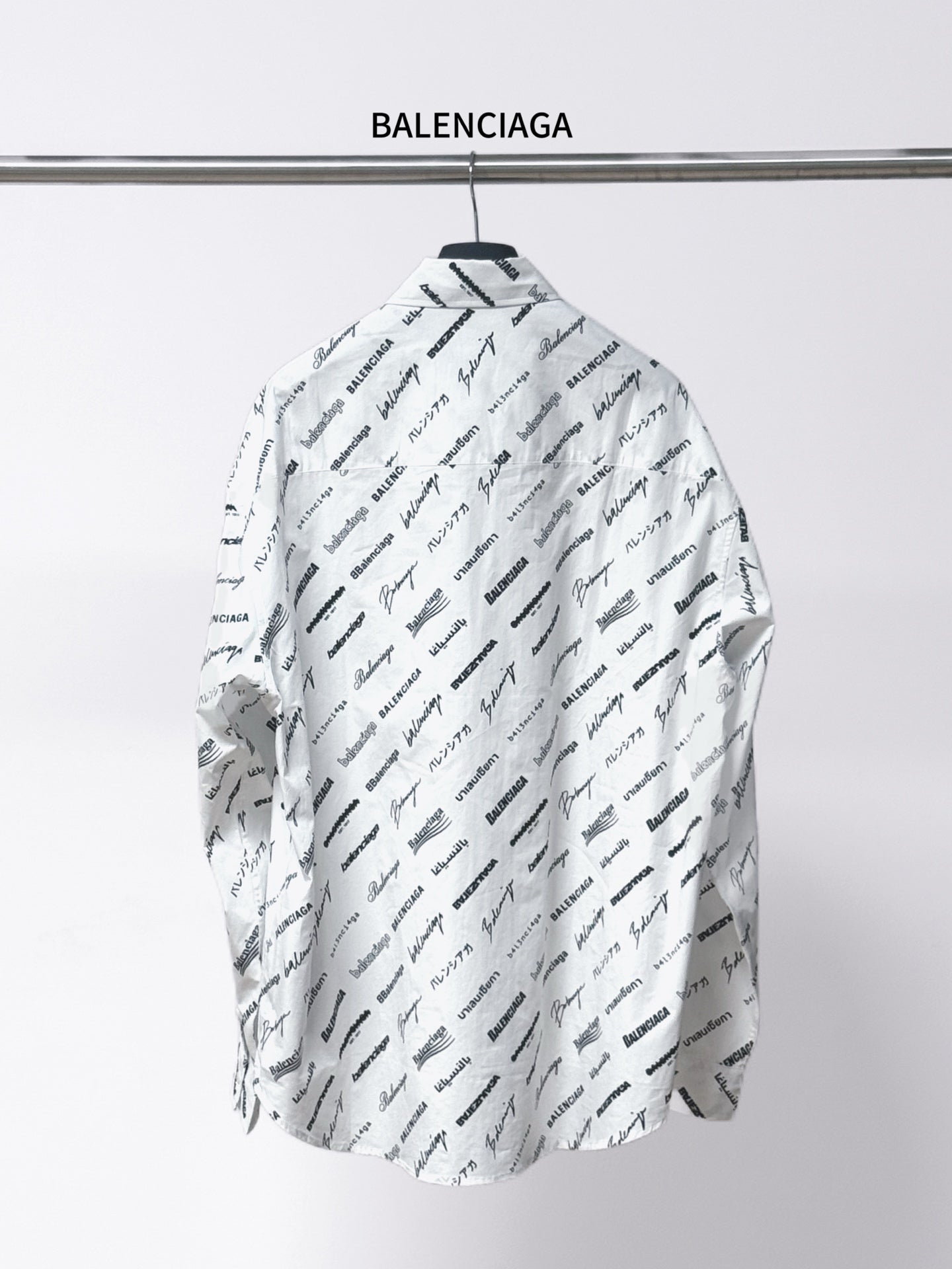 White long-sleeve shirt with spread collar, black Balenciaga script print on back