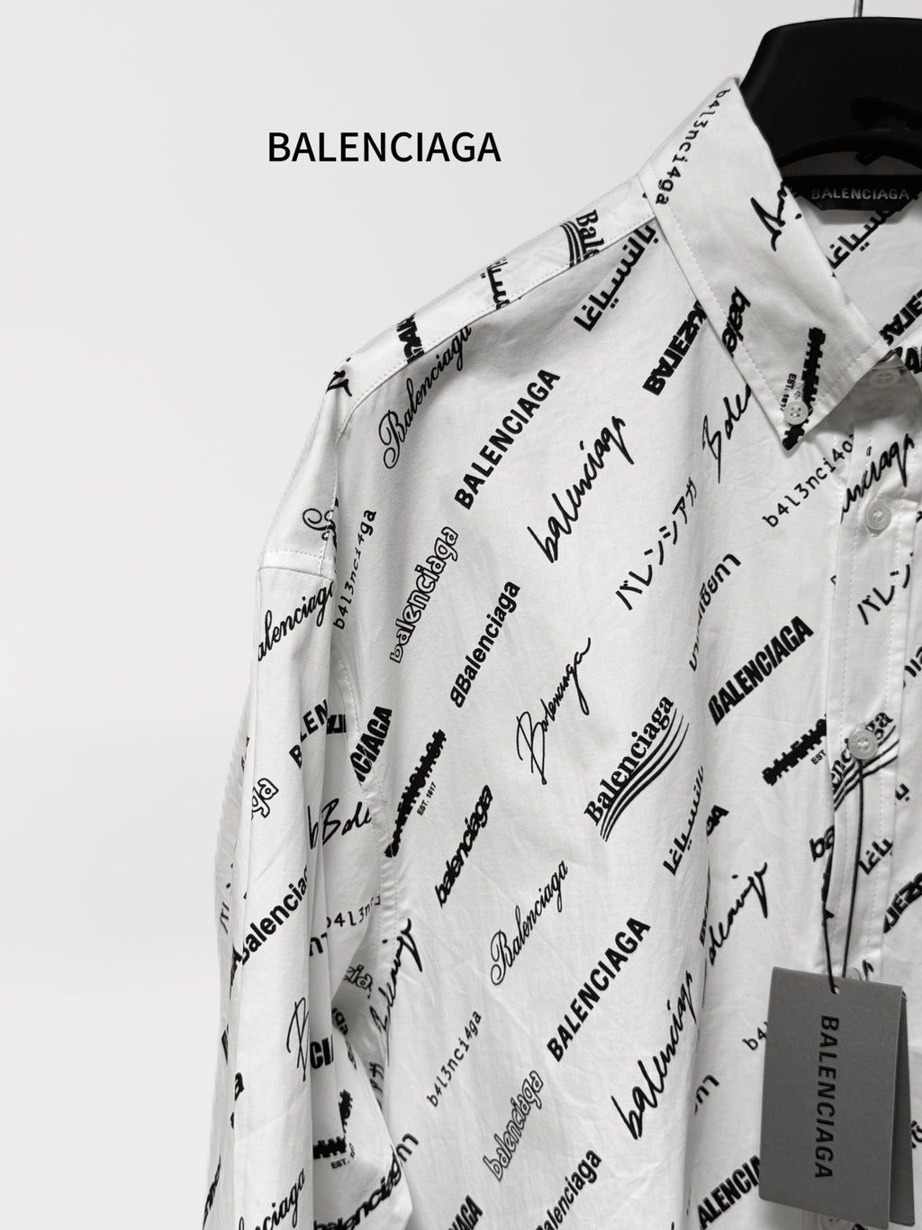 White long-sleeve shirt with black Balenciaga print, shown from shoulder and sleeve