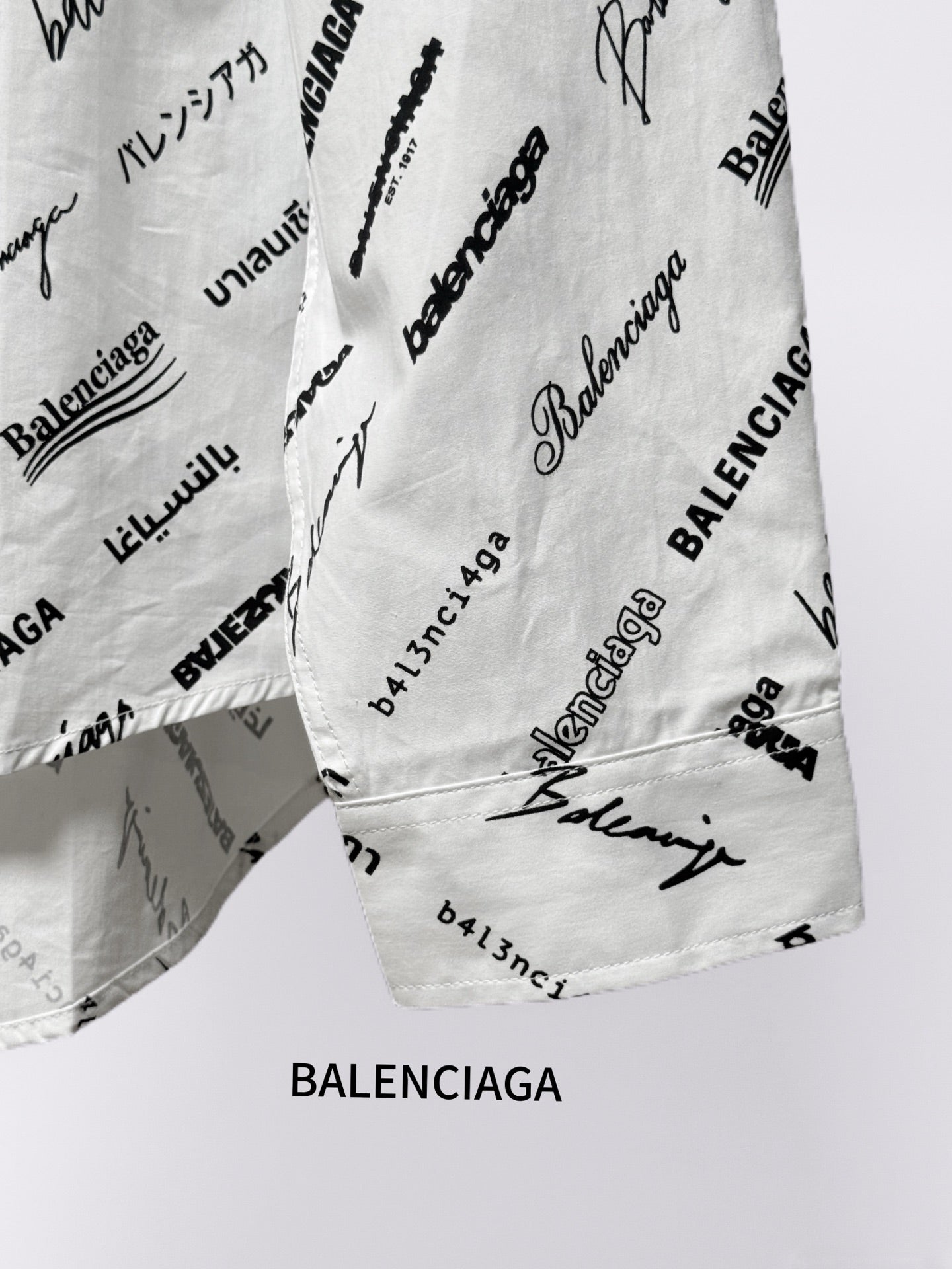 White shirt hem and lower side seam with black Balenciaga logo print