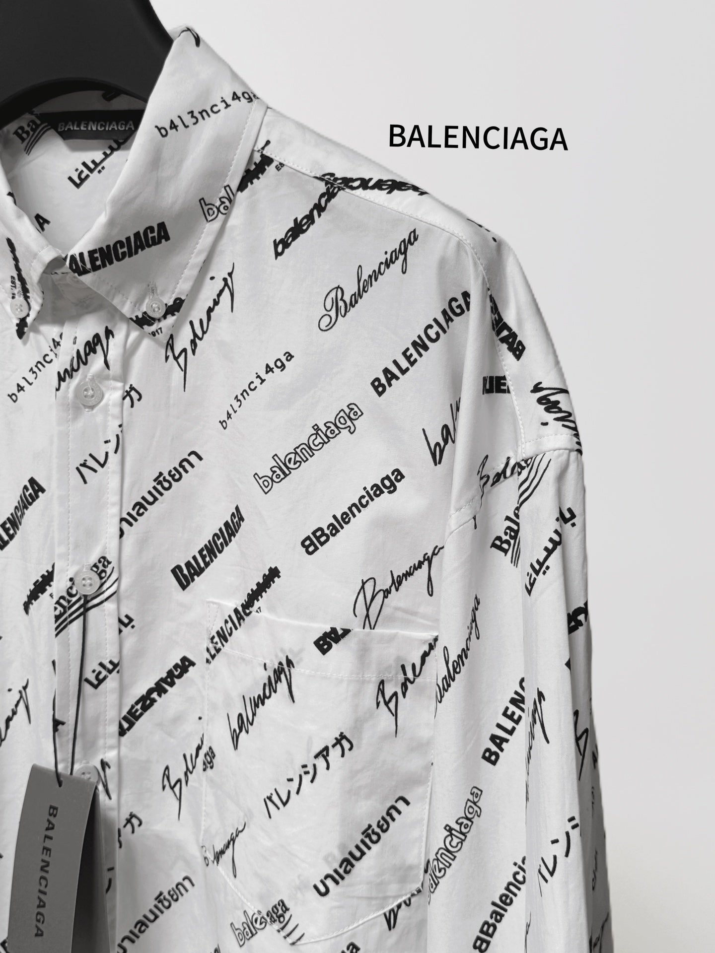 White long-sleeve shirt with scattered black Balenciaga logo and signature text