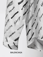 White logo-print shirt fabric close-up with black script and scattered text