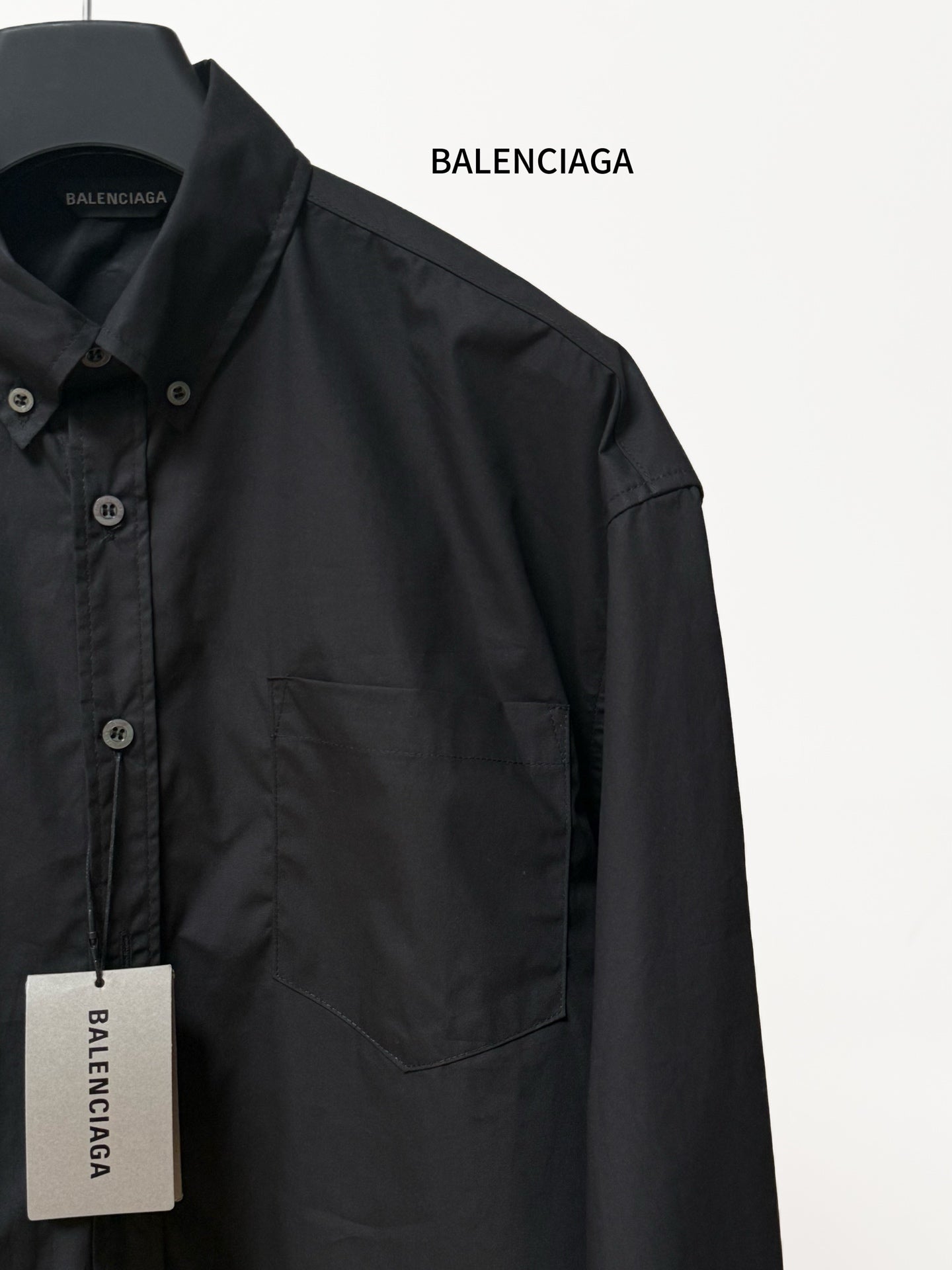 Long-sleeve button-up shirt by Balenciaga, dark black, chest pocket and sleeve detail.