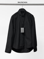 Long-sleeve button-up shirt by Balenciaga, dark black, front view with button placket.