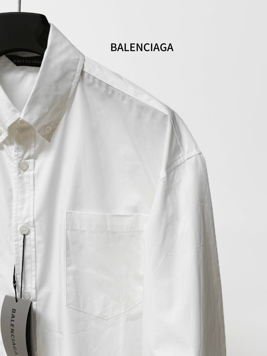 Balenciaga long-sleeve button-up shirt, white, close-up of button placket and pocket.