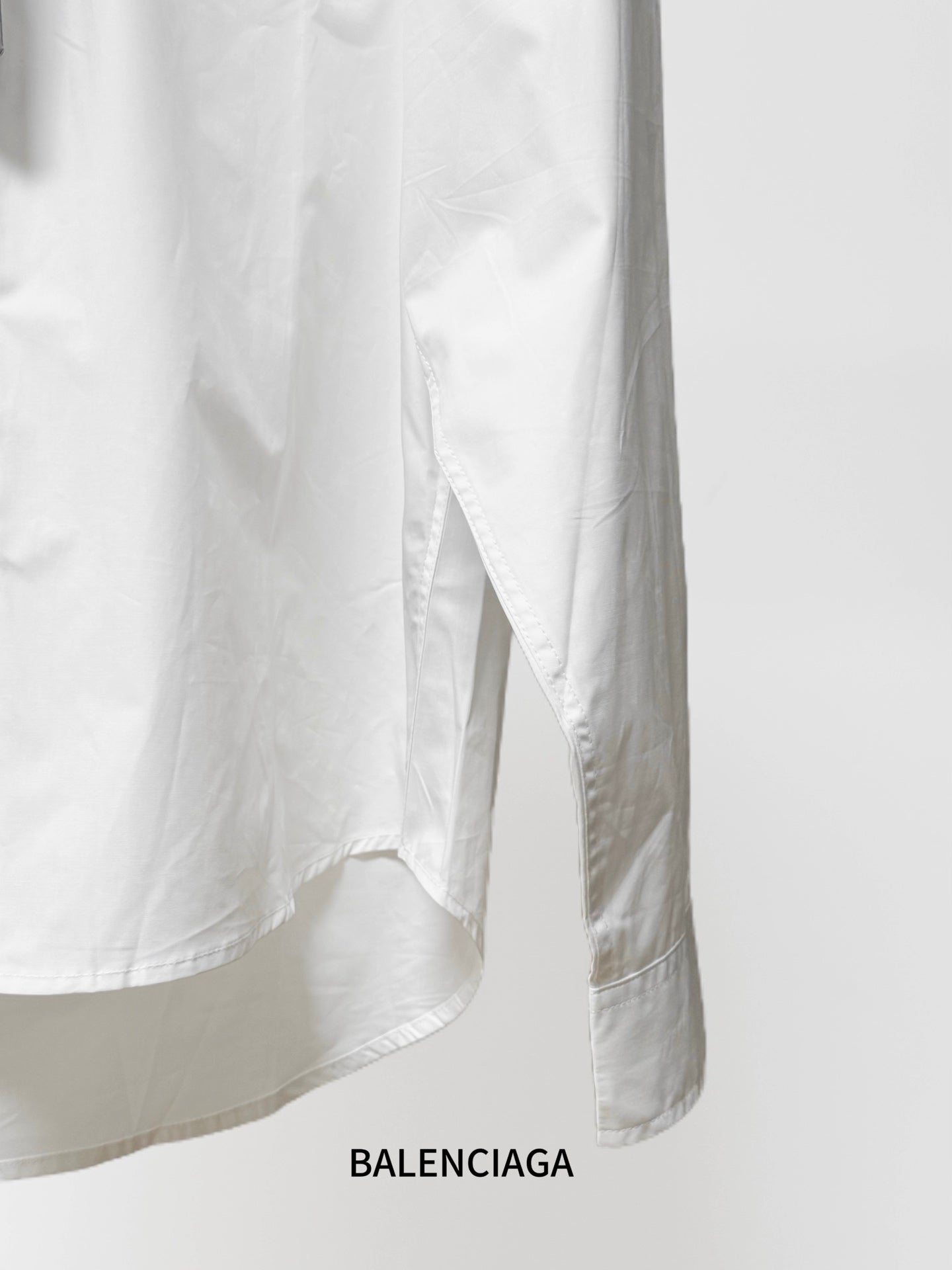 Balenciaga long-sleeve button-up shirt, white, hem and side seam with drape.