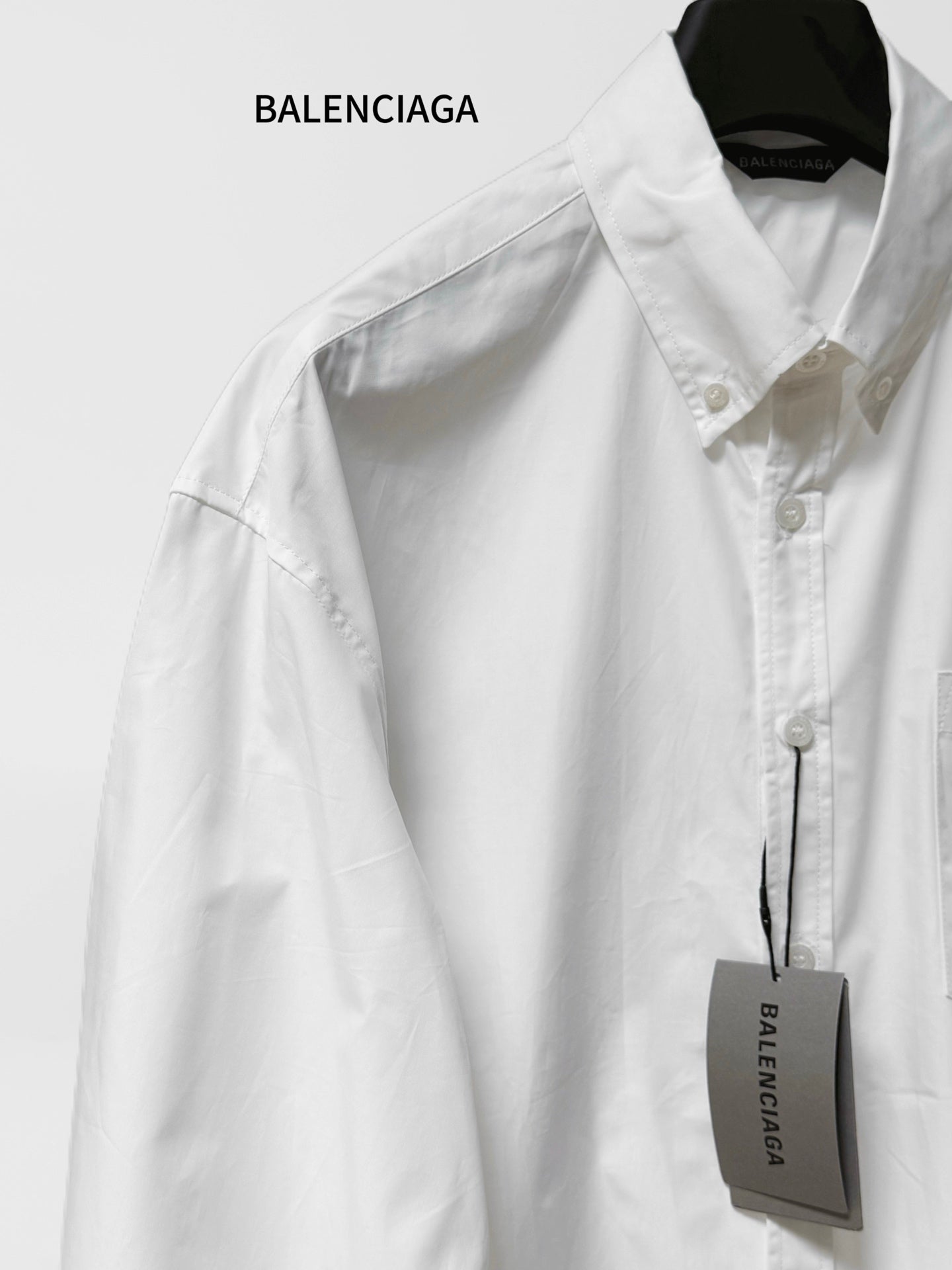 Balenciaga long-sleeve button-up shirt, white, shoulder seam and front button detail.