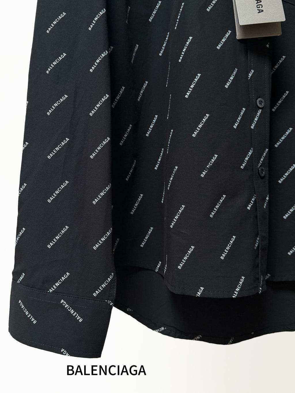 Balenciaga long-sleeve shirt detail, black fabric with repeating logo pattern and button
