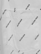 Long-sleeve shirt fabric close-up with allover black logo print and stitched seam detail