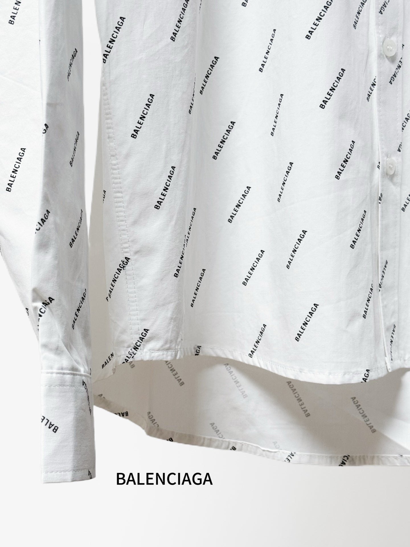 Long-sleeve shirt hem with allover black logo pattern and gathered fabric at the bottom