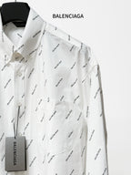 Long-sleeve button-up shirt with black logo pattern, chest pocket and hanging tag