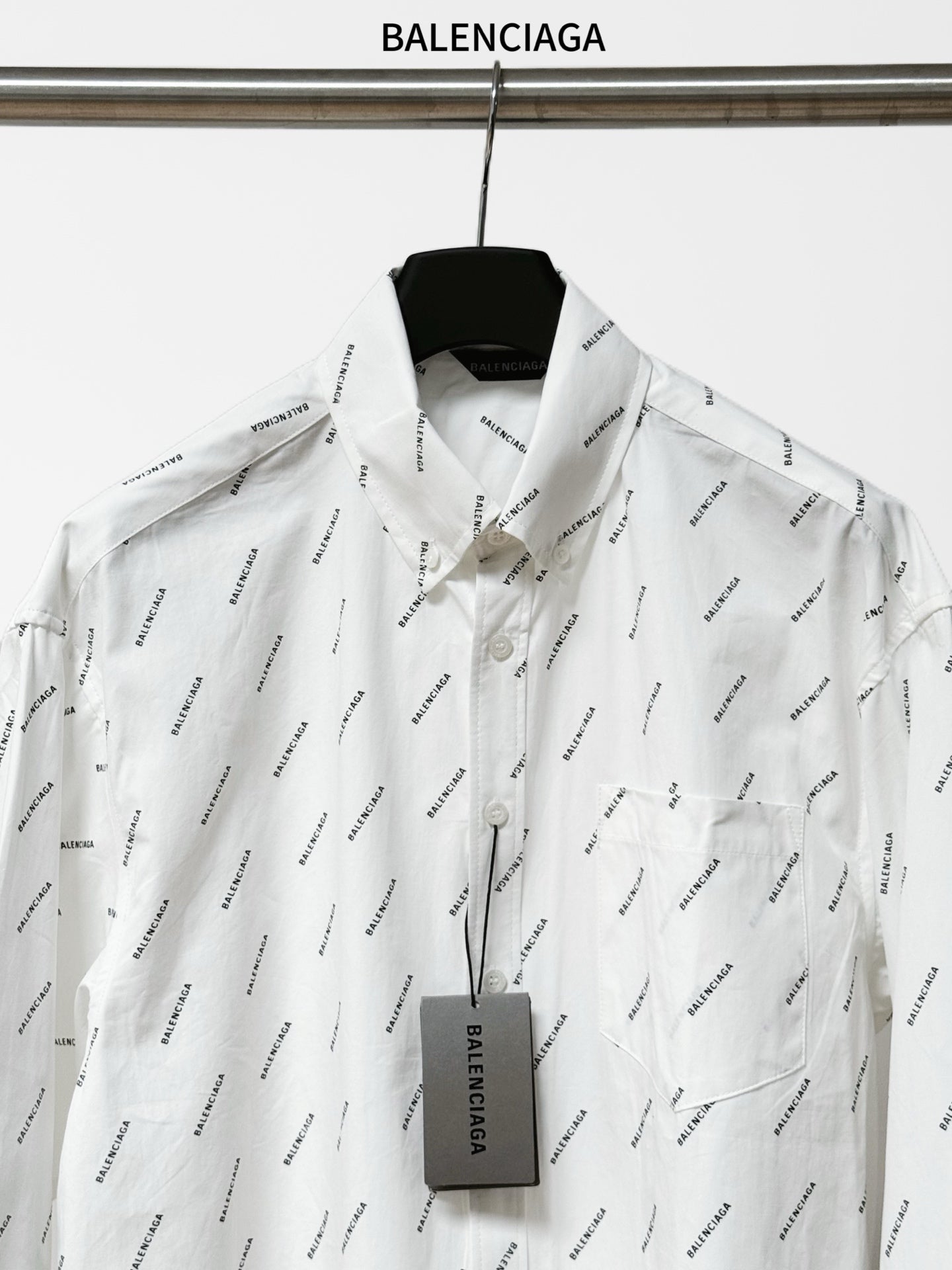 Long-sleeve button-up shirt front view with black logo print and buttoned placket