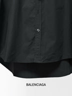 Black long-sleeve button-up shirt with center front buttons and curved hem