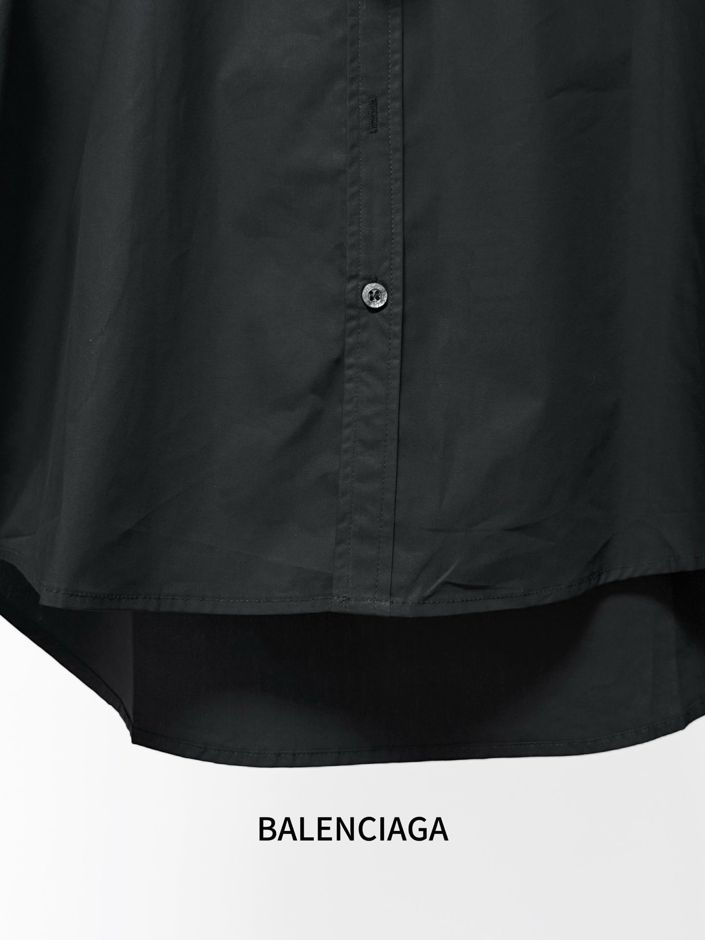 Black long-sleeve button-up shirt with center front buttons and curved hem