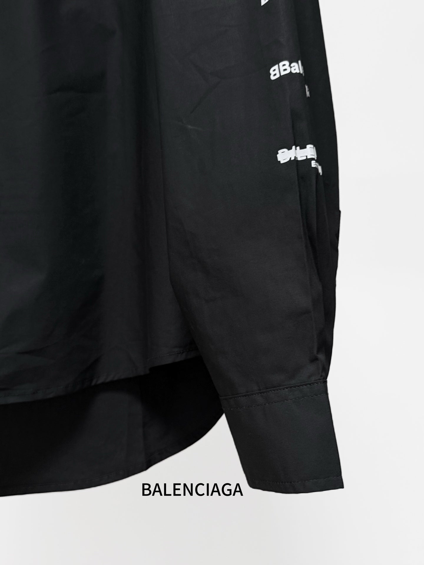 Black long-sleeve button-up shirt sleeve graphic text and cuff hem detail