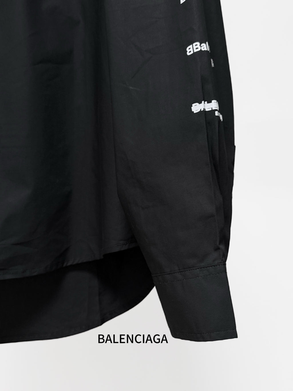 Black long-sleeve shirt hem and sleeve cuff with BALENCIAGA logo print.