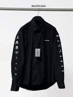 Black long-sleeve button-up shirt with Balenciaga sleeve text and front pocket detail