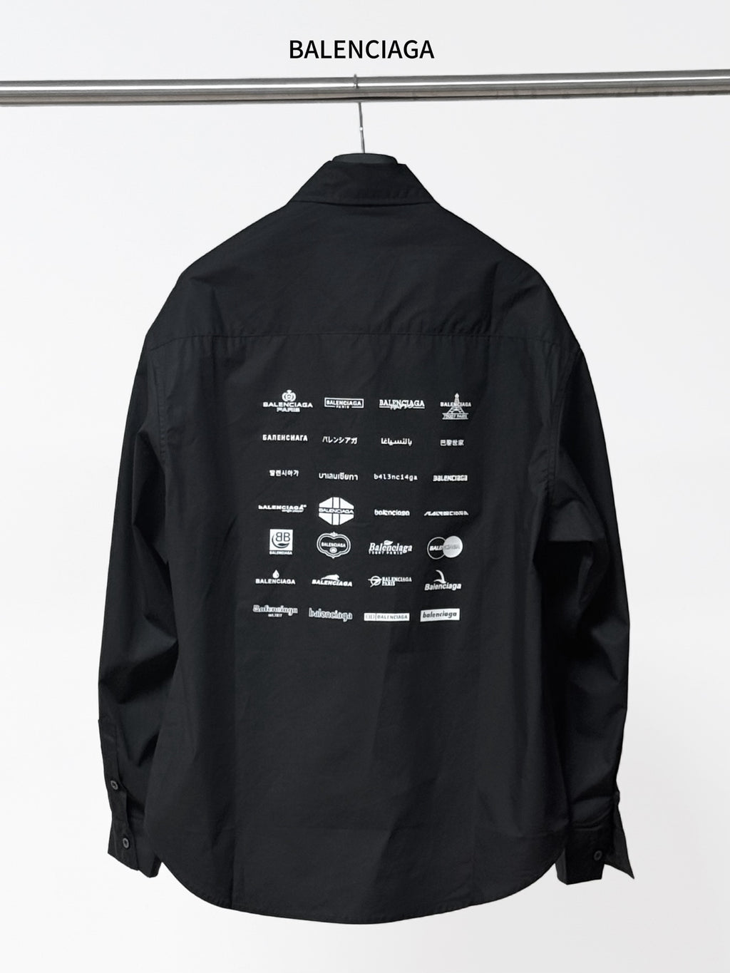 Black long-sleeve button-up shirt with back graphic text and icons, collar and placket visible