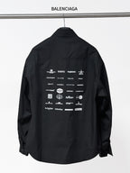Black long-sleeve button-up shirt with back graphic text and icons, collar and placket visible
