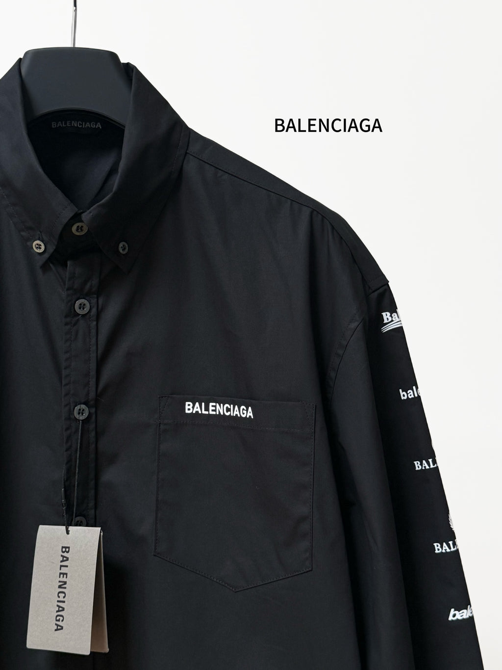 Black long-sleeve button-up shirt detail with BALENCIAGA chest pocket logo and label.