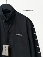 Black long-sleeve button-up shirt detail with BALENCIAGA chest pocket logo and label.