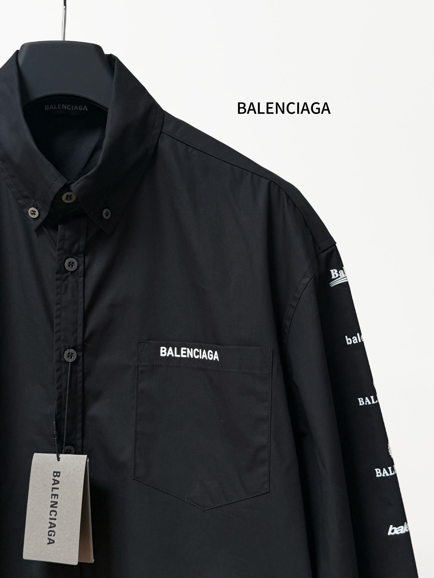 Black long-sleeve button-up shirt detail with BALENCIAGA chest pocket logo and label.