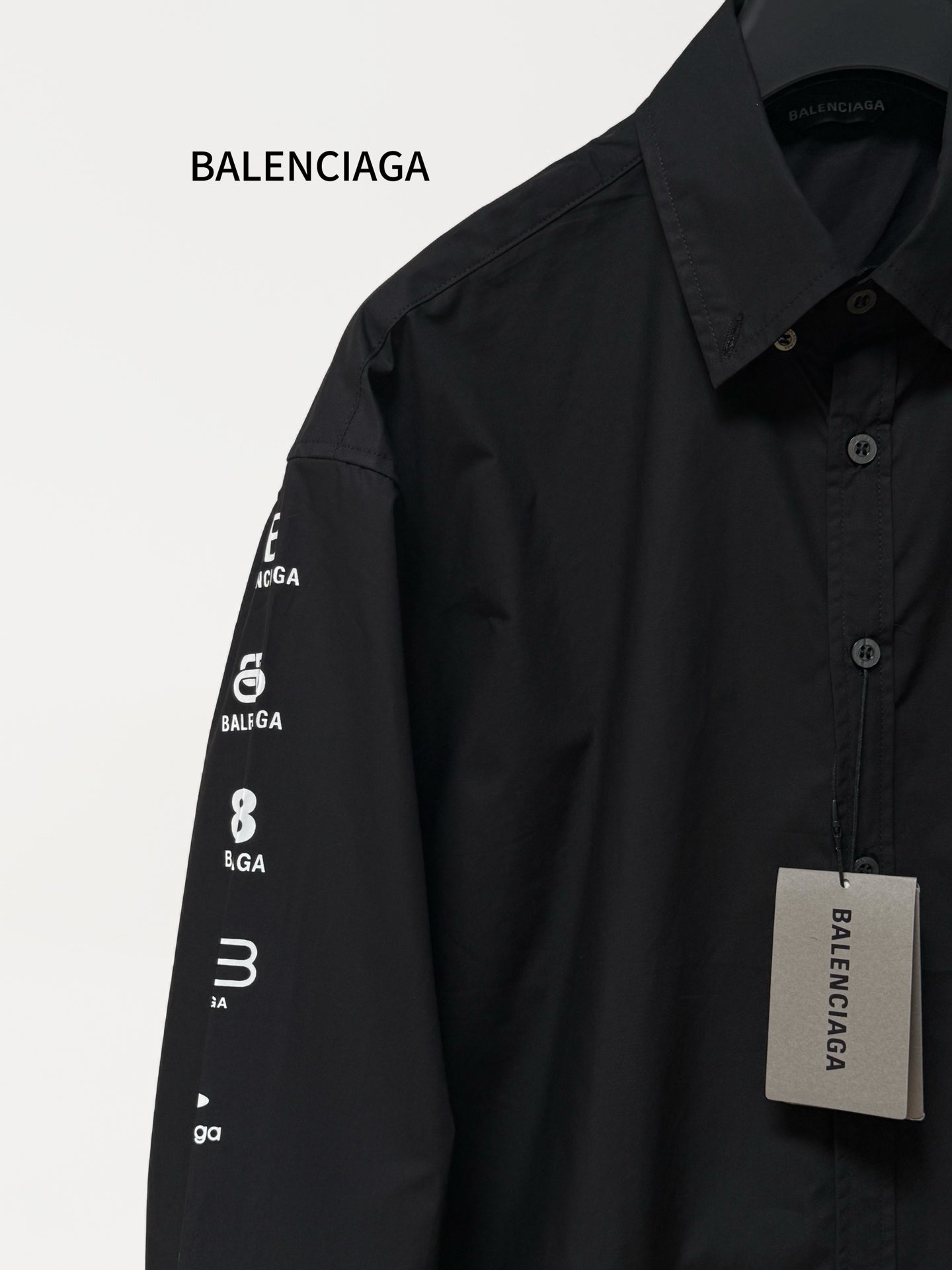 Black long-sleeve button-up shirt with printed Balenciaga sleeve text and front buttons