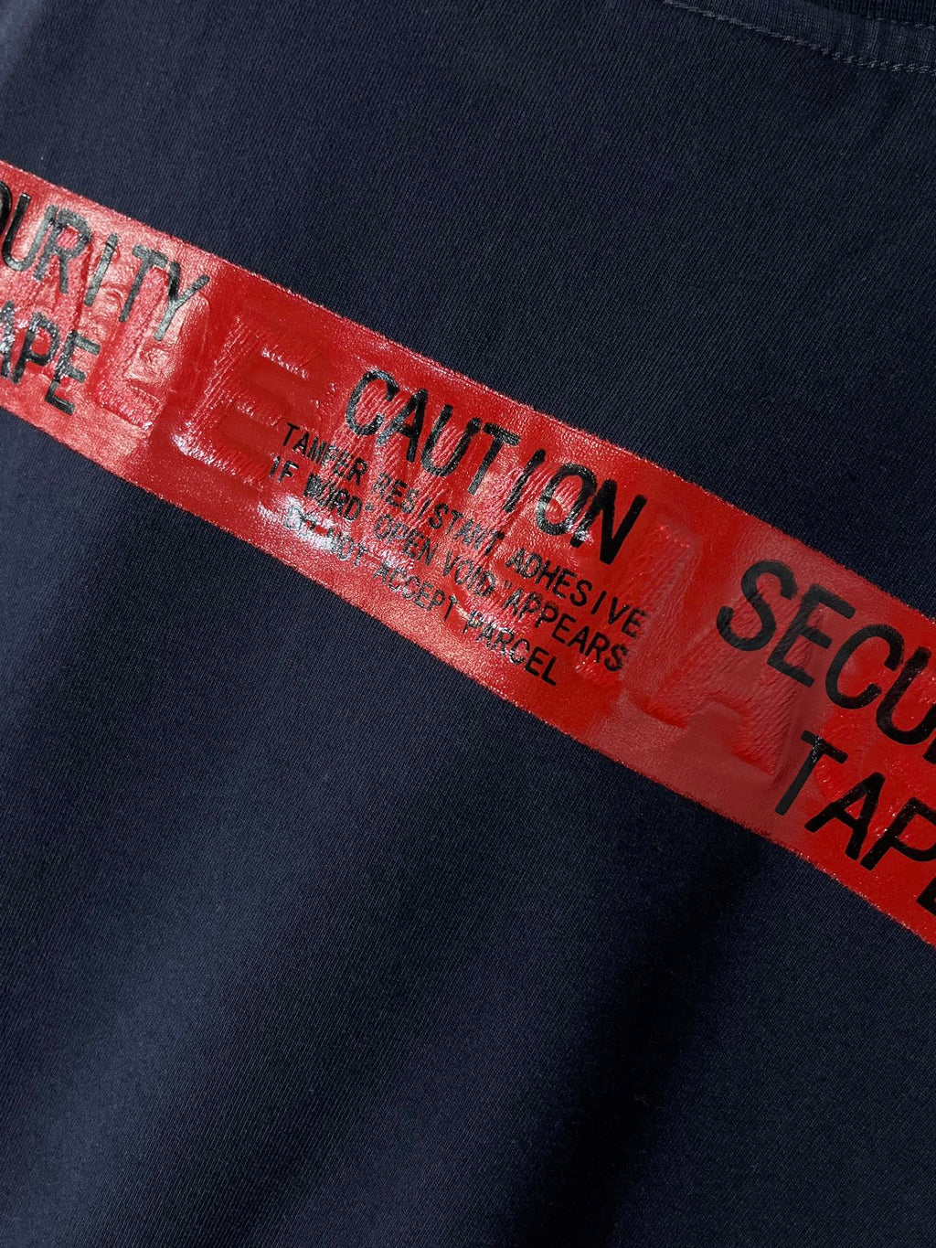 Navy T-shirt with close-up red graphic tape-style text band