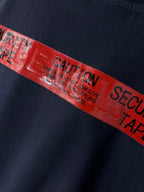 Navy T-shirt with close-up red graphic tape-style text band