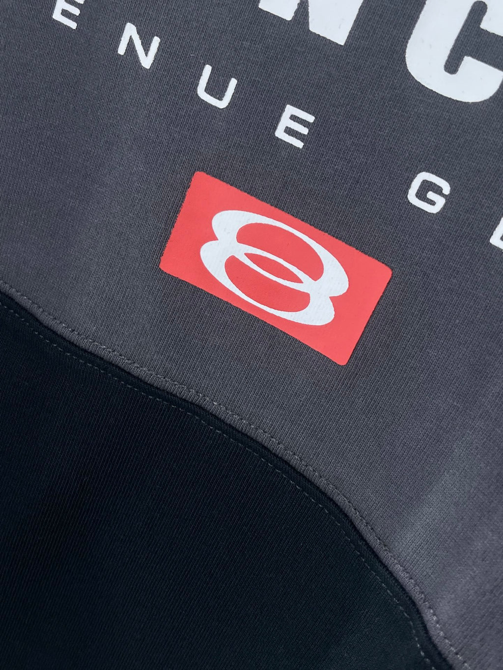 BALENCIAGA red emblem patch on dark T-shirt fabric